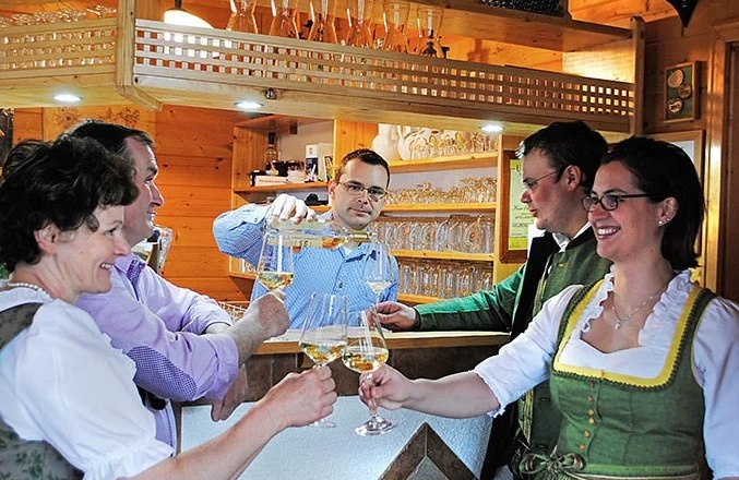 Menschen stoßen an einer gemütlichen Theke mit Getränken an.