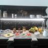 Breakfast buffet with fruit, cold cuts, cheese, jam and drinks on a decorative table.