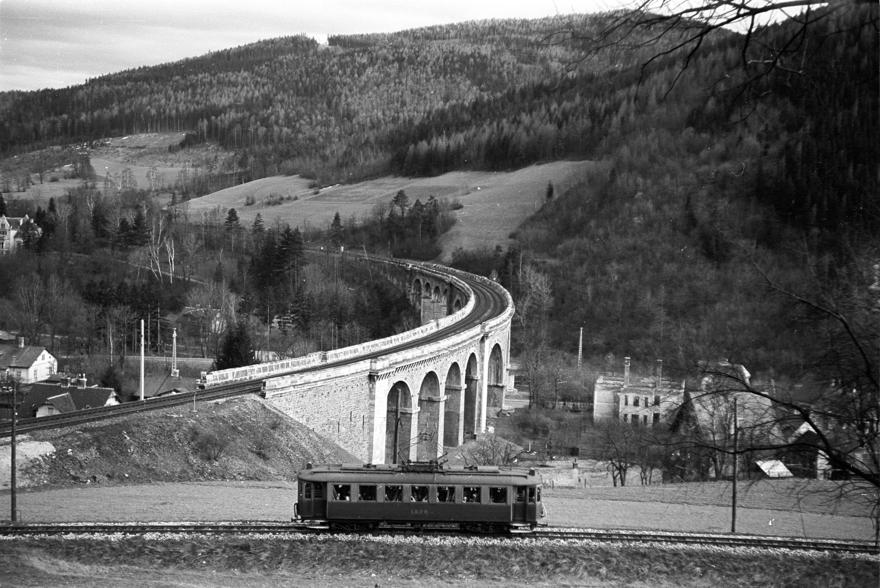 historische Aufnahme der Höllentalbahn während der Fahrt auf Schienen, dahinter das Schwarzatal Viadukt