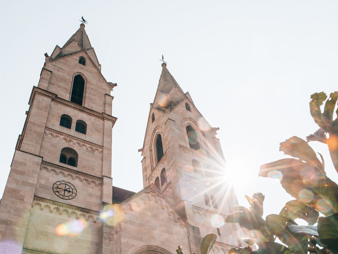 Die majestätischen Türme der Kirche ragen in den strahlend blauen Himmel und fangen das Licht der Sonne ein. Umgeben von üppigem Grün, strahlt dieser Ort eine friedliche Atmosphäre aus, die zum Verweilen einlädt. Hier vereinen sich Geschichte und Natur in harmonischer Weise.