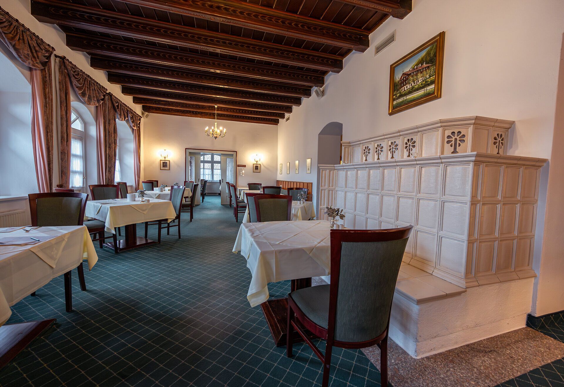 In einem einladenden Restaurant mit rustikalem Charme genießen Gäste die gemütliche Atmosphäre unter den hohen Holzdecken. Die geschmackvoll gedeckten Tische laden dazu ein, regionale Köstlichkeiten zu probieren und die entspannte Stimmung zu erleben.