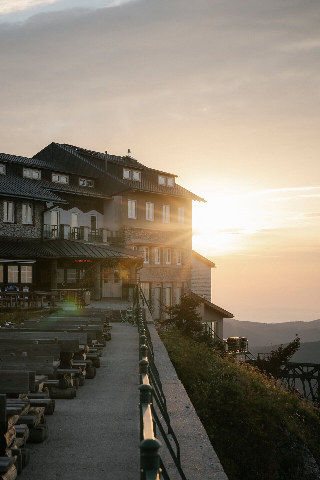 Sonnenaufgang hinter dem Raxalm-Berggasthof mit Terrasse im Vordergrund
