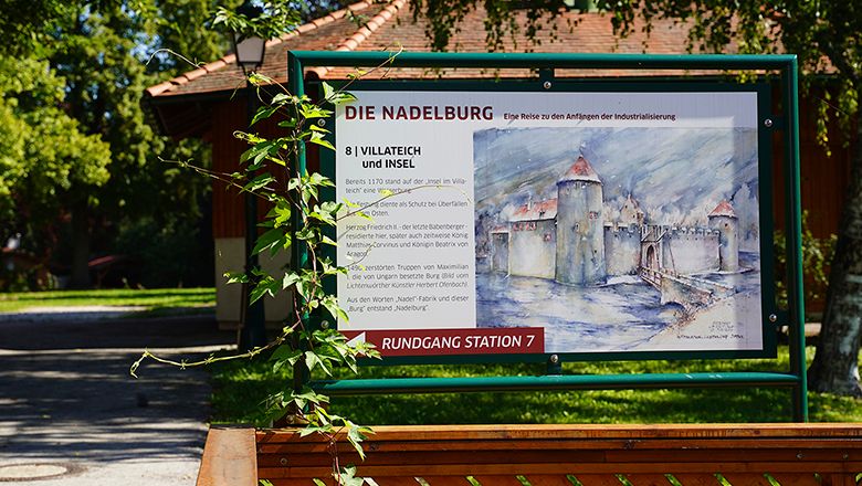 Information sign about the Nadelburg in a park.