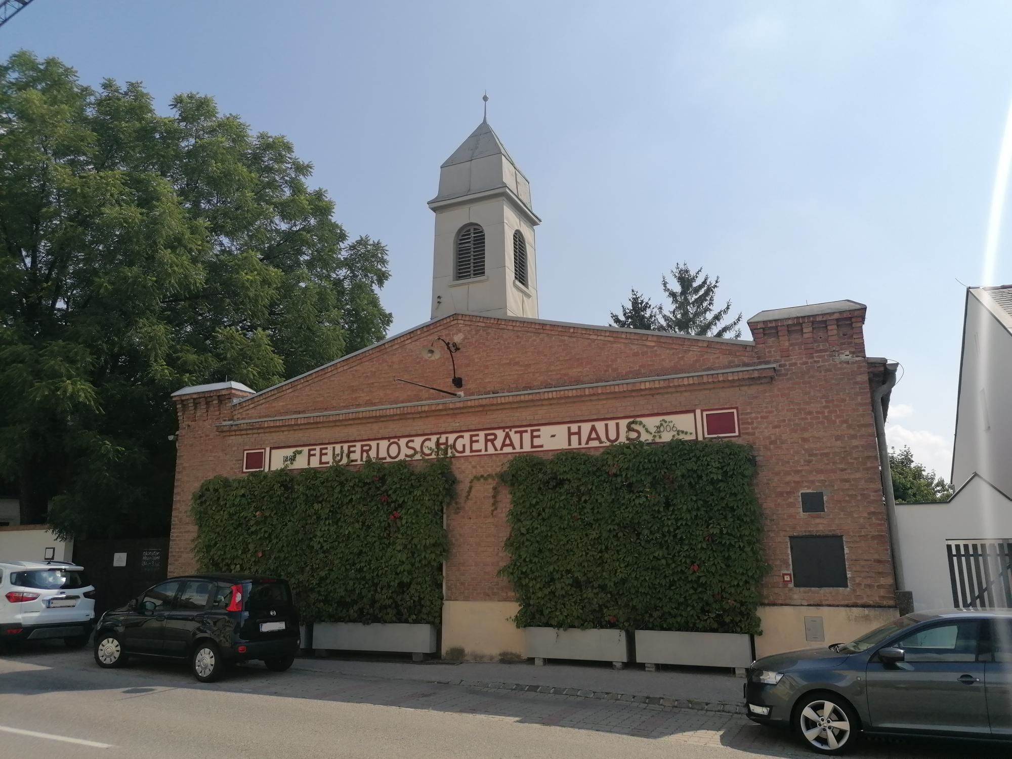 Altes Feuerwehrhaus in Bad Fischau mit Backsteinfassade und Turm.