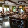 Cozy dining room with wooden furniture, decorated with flowers and tablecloths.