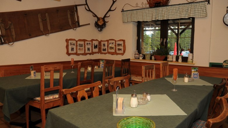 Innenansicht einer rustikalen Berghütte mit Holzmöbeln und Dekorationen.