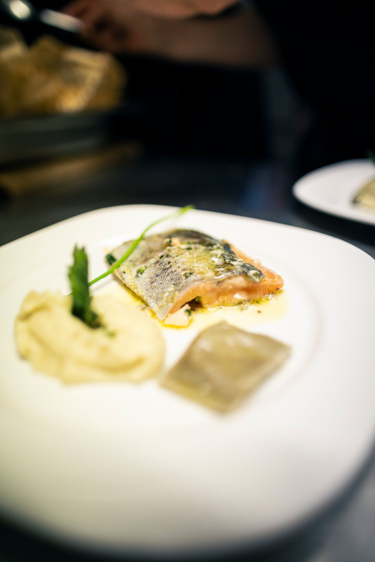 Fein angerichtetes Gericht mit Fisch auf einem weißen Teller .