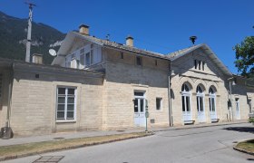 Bahnhof Payerbach-Reichenau mit historischem Gebäude und blauen Himmel.