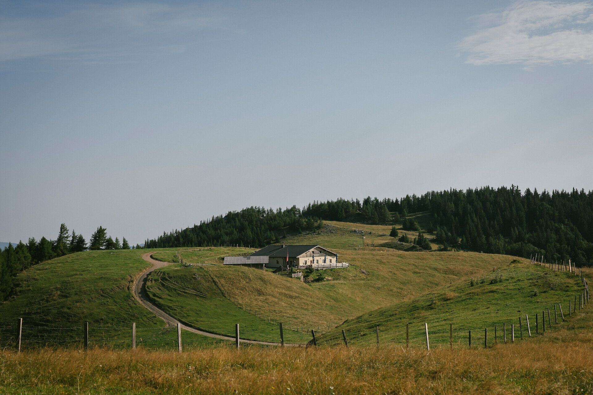 Panoramic view of the Almreserlhaus on the Schneeberg, nestled among rolling hills