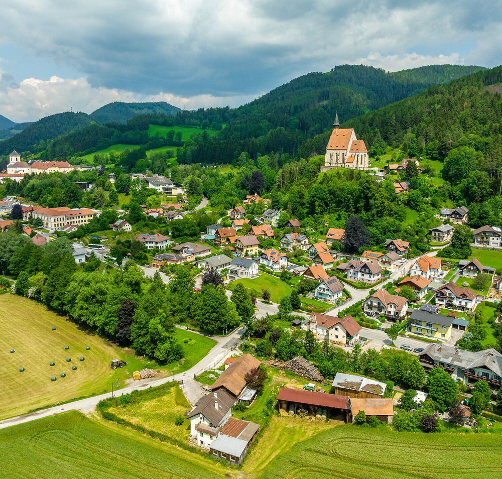 Luftansicht Kirchberg am Wechsel. Vorne rechts ist der Gasthof Pension St. Wolfgang zu erkennen, im Hintergrund Teile von Kirchberg am Wechsel inklusive der Wolfgangskirche.