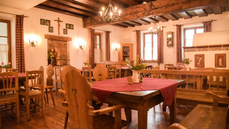 Cozy parlor with wooden furniture, red tablecloths and chandeliers.