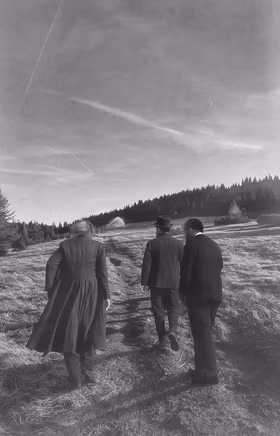 Schwarz weiß Foto, dass drei historische Personen von hinten zeigt, wie diese auf der Rax gehen