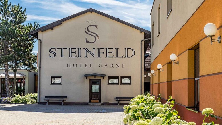 Außenansicht des Hotels Steinfeld mit Pflanzen im Vordergrund.