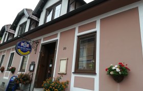 Exterior view of a building with 'Puntigamer' sign and floral decoration.