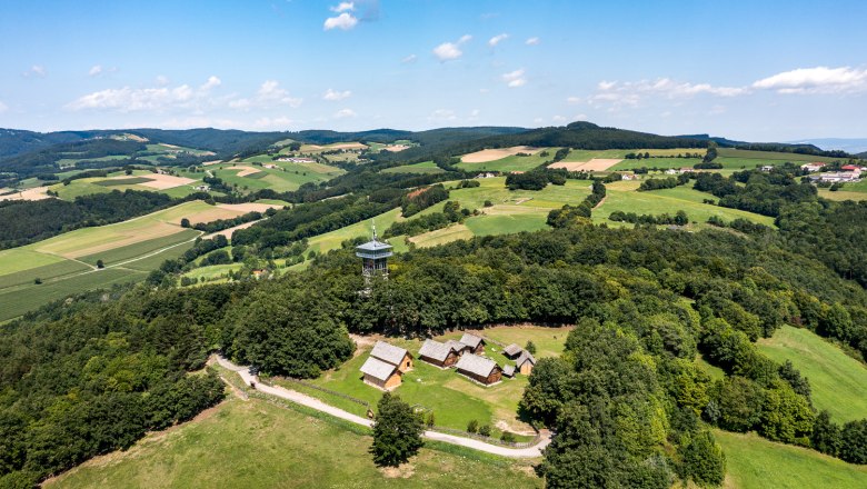Luftaufnahme des Keltendorfs Schwarzenbach mit Aussichtsturm inmitten grüner Landschaft.