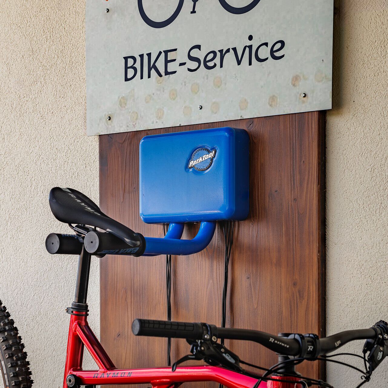 Der Alpengasthof Enzian bietet einen eigenen "Bike-Service" Platz an der Wand mit Wandhaken, auf dem gerade ein Rad aufgehängt ist. 