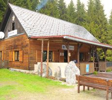 bewirtschaftet Holzhütte am Preiner Gscheid, davor ein Dachvorsprung und Holztische und Bänke