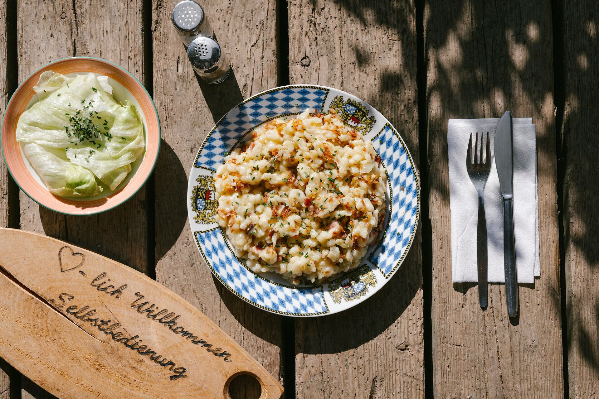 Geröstete Knödel mit Ei und Salat auf einem Holztisch in der Edelweißhütte am Schneeberg
