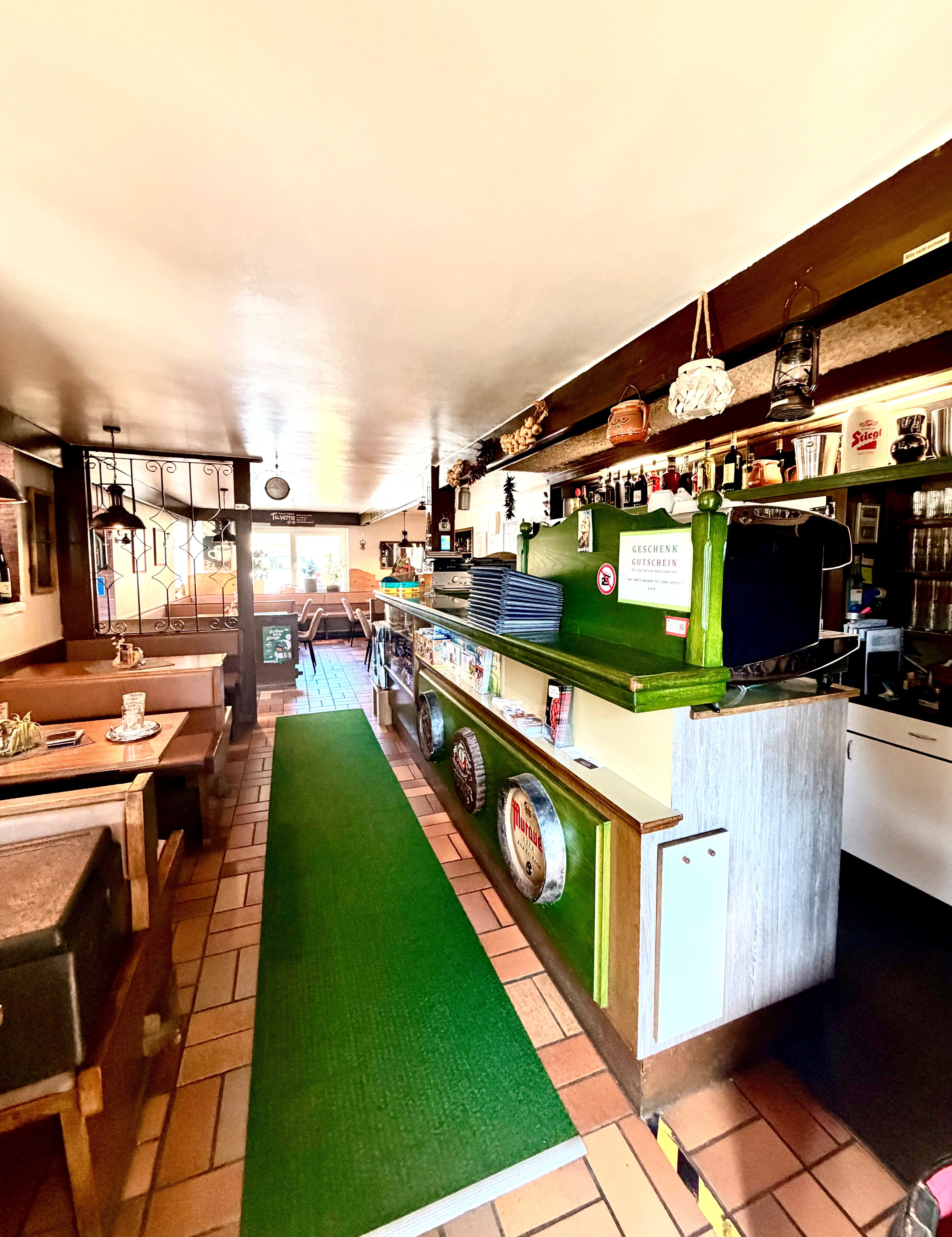 Pizzeria interior view with tables and bar 