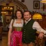 A couple in traditional Bavarian costume in a rustic inn.