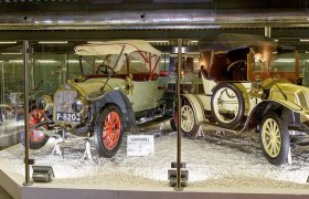 Historische Autos im Automobilmuseum hinter Glas ausgestellt.