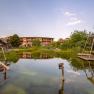 Naturhotel Molzbachhof mit Teich und Liegestühlen im Vordergrund.