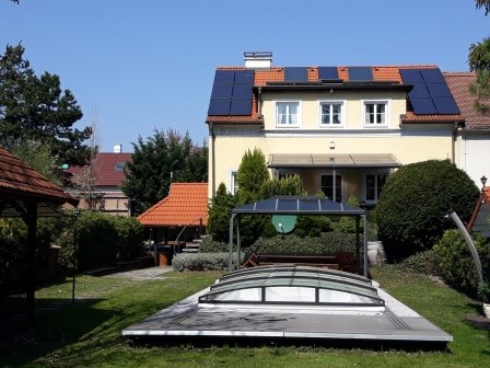 House with pool, © bed and pool A house with solar panels and a covered pool in the garden.