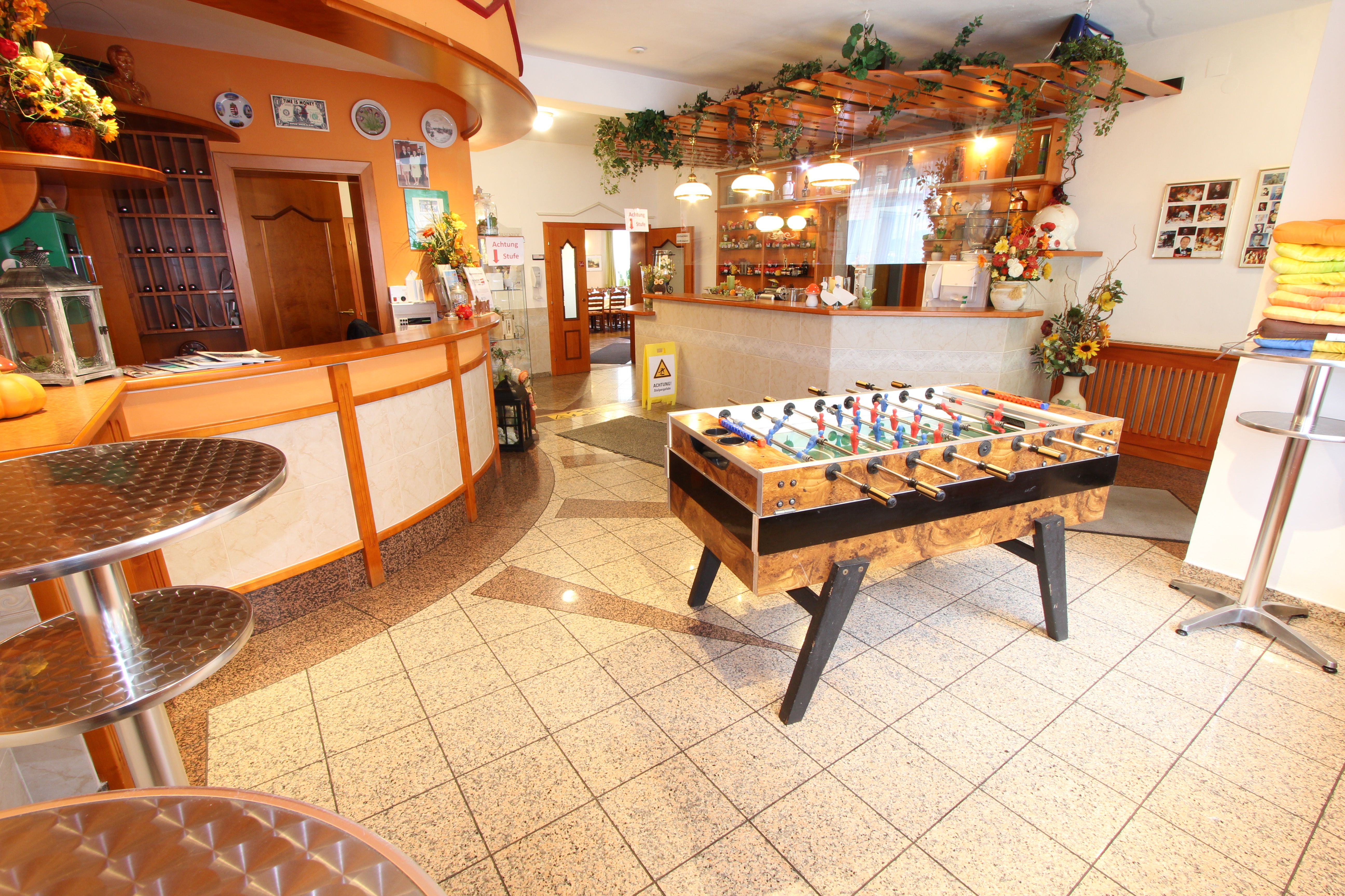 Empfangsbereich mit Tischfußballtisch und Theke.