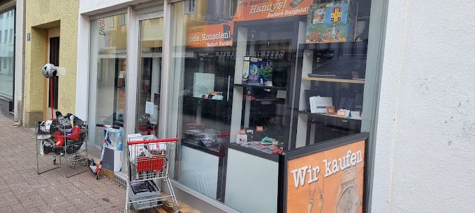 Außenansicht eines Geschäfts mit Schaufenster und Einkaufswagen voller Waren.