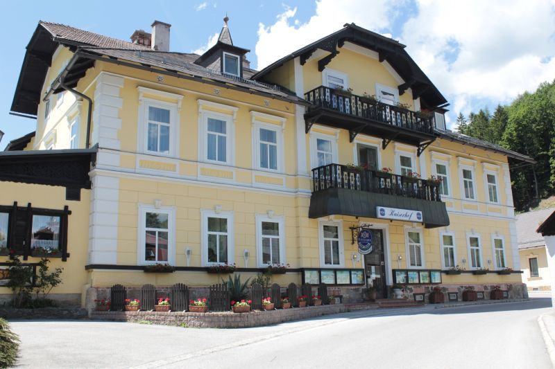 Gelbes Gebäude mit Balkon und Blumenkästen, Land-Pension Kaiserhof.