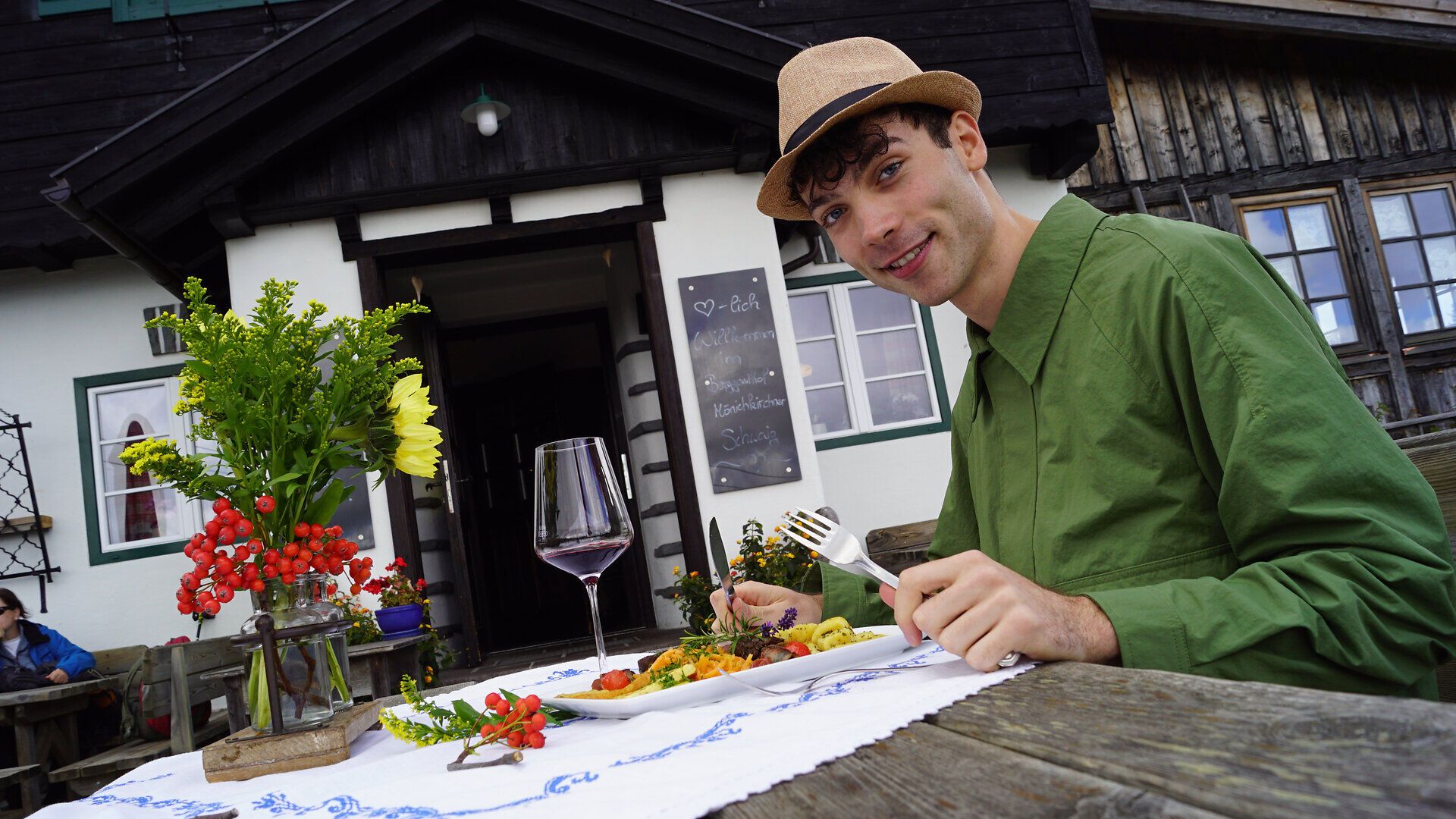 Genießen Sie eine köstliche Mahlzeit inmitten der atemberaubenden Berglandschaft. Der Duft frischer Kräuter und die Farben der Blumen um den Tisch schaffen eine einladende Atmosphäre, die zum Verweilen einlädt.