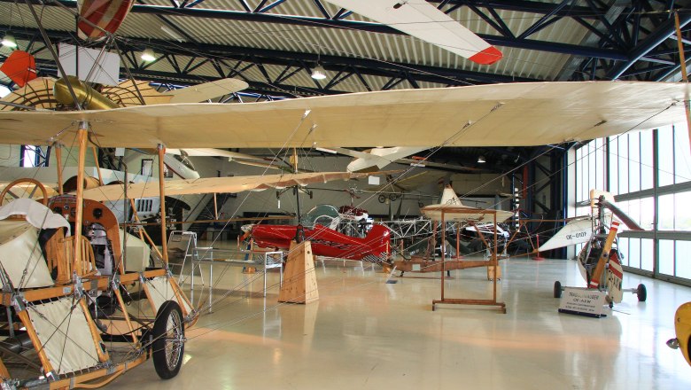 Innenansicht eines Flugmuseums mit historischen Flugzeugen und Segelflugzeugen.
