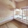 Multi-bed room with wooden paneling and bunk beds in the Naturfreundehaus Knofeleben.