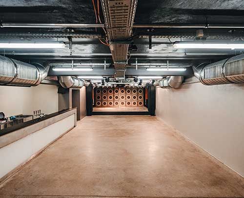 Interior view of a modern hall with visible ventilation pipes.