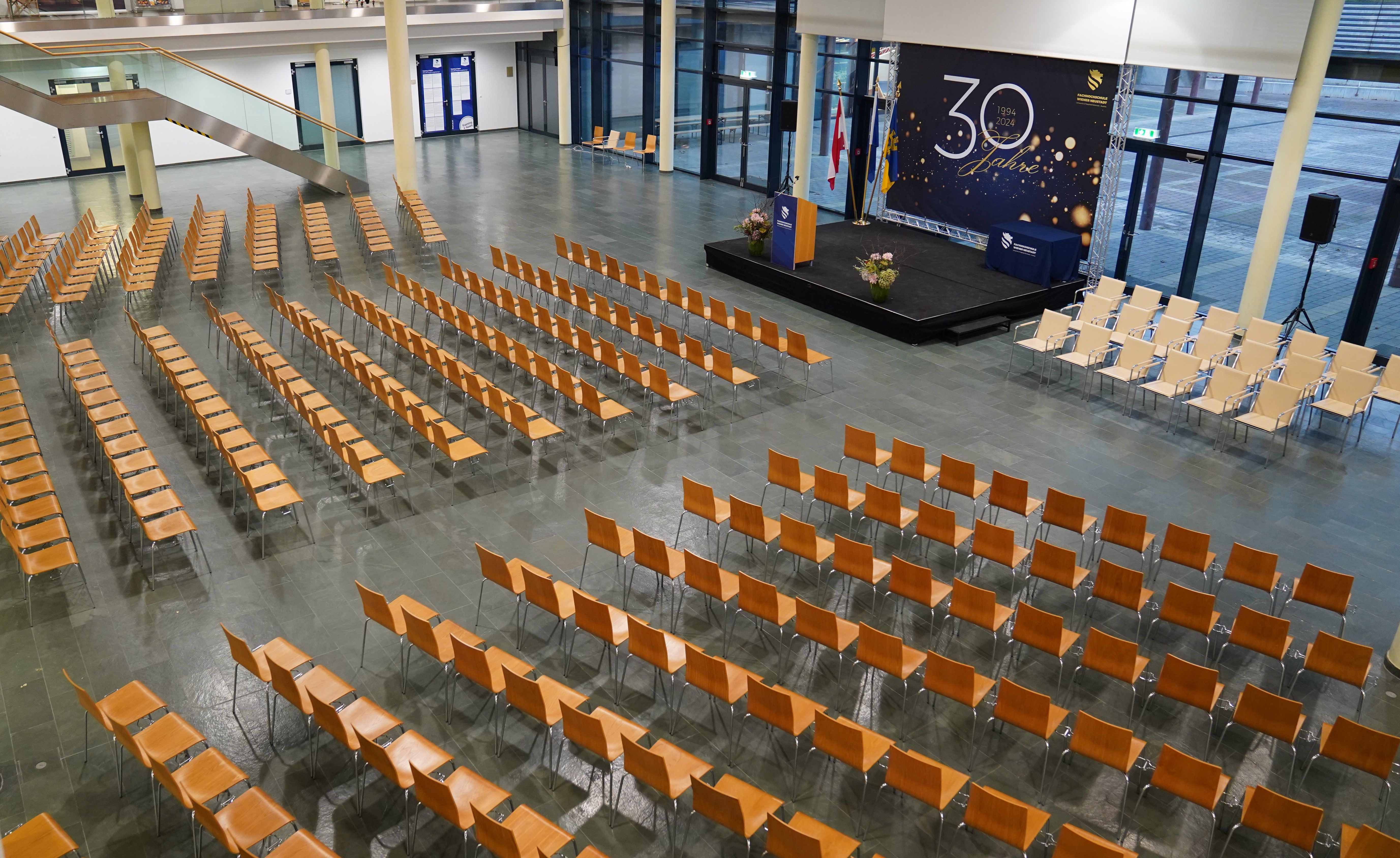 Große Aule mit Theaterbestuhlung und Bühne vor Fensterfront