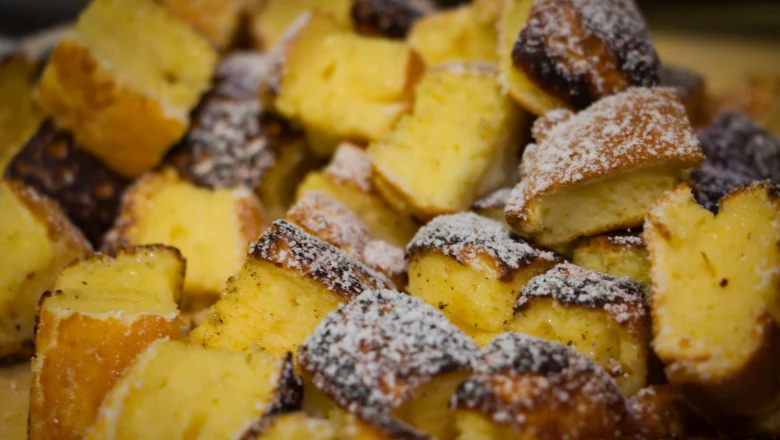 Nahaufnahme von gestückeltem, goldbraun gebackenem Sauerrahmschmarrn.