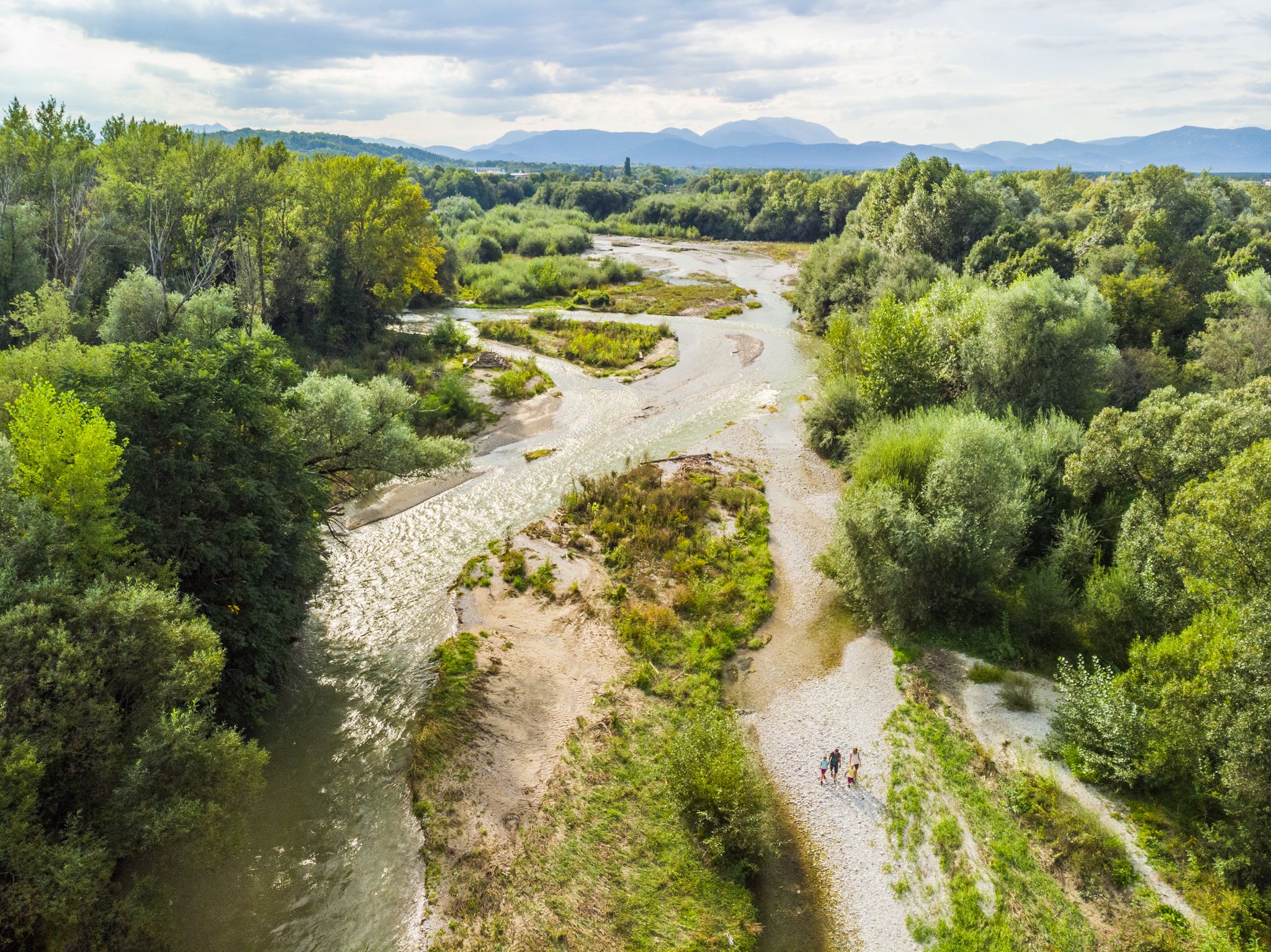 Luftaufnahme des Leitha-Ursprungs in Lanzenkirchen mit Fluss und grüner Vegetation.