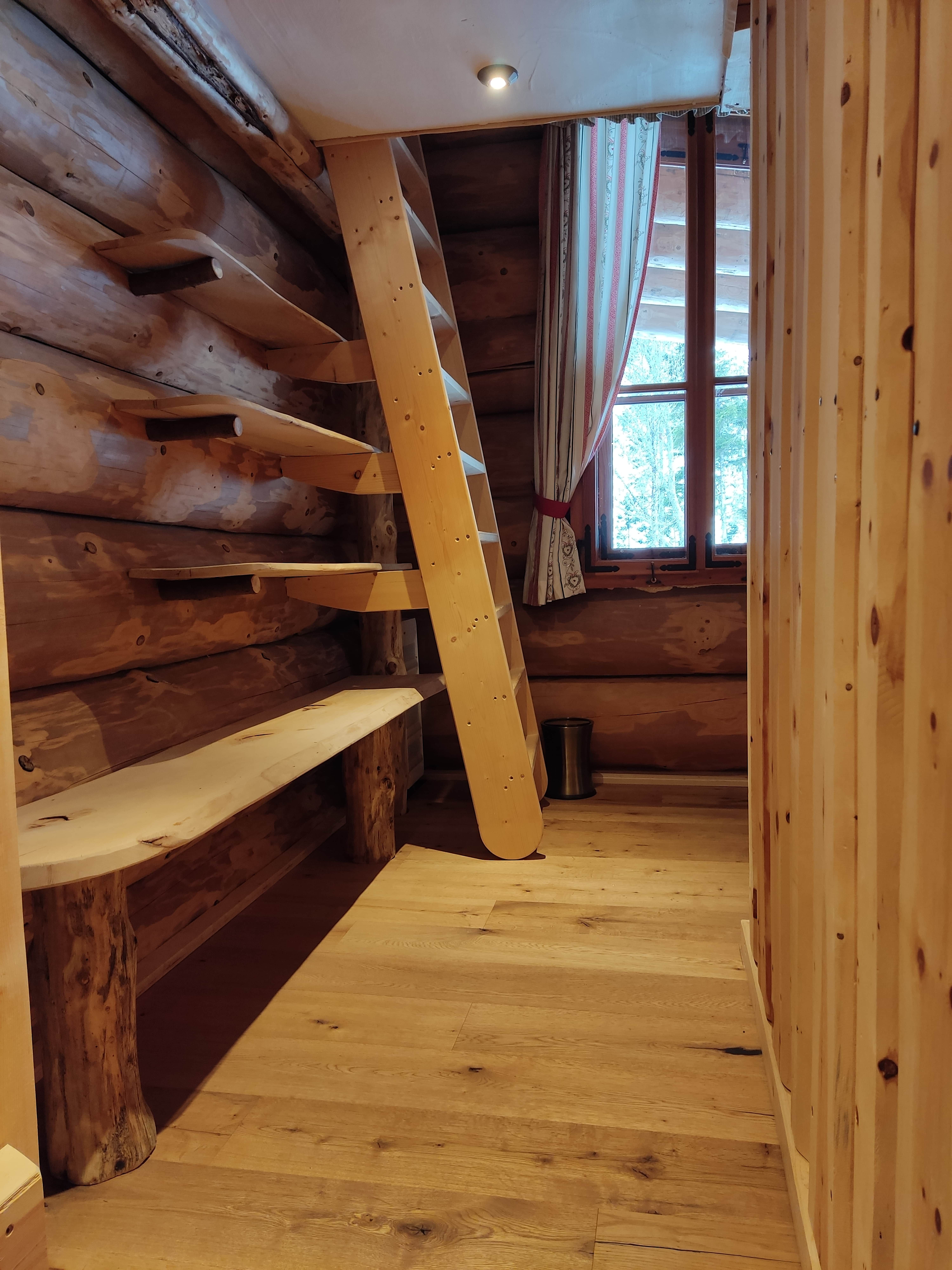 Holzinterieur mit Leiter und Fenster in einem Raum.