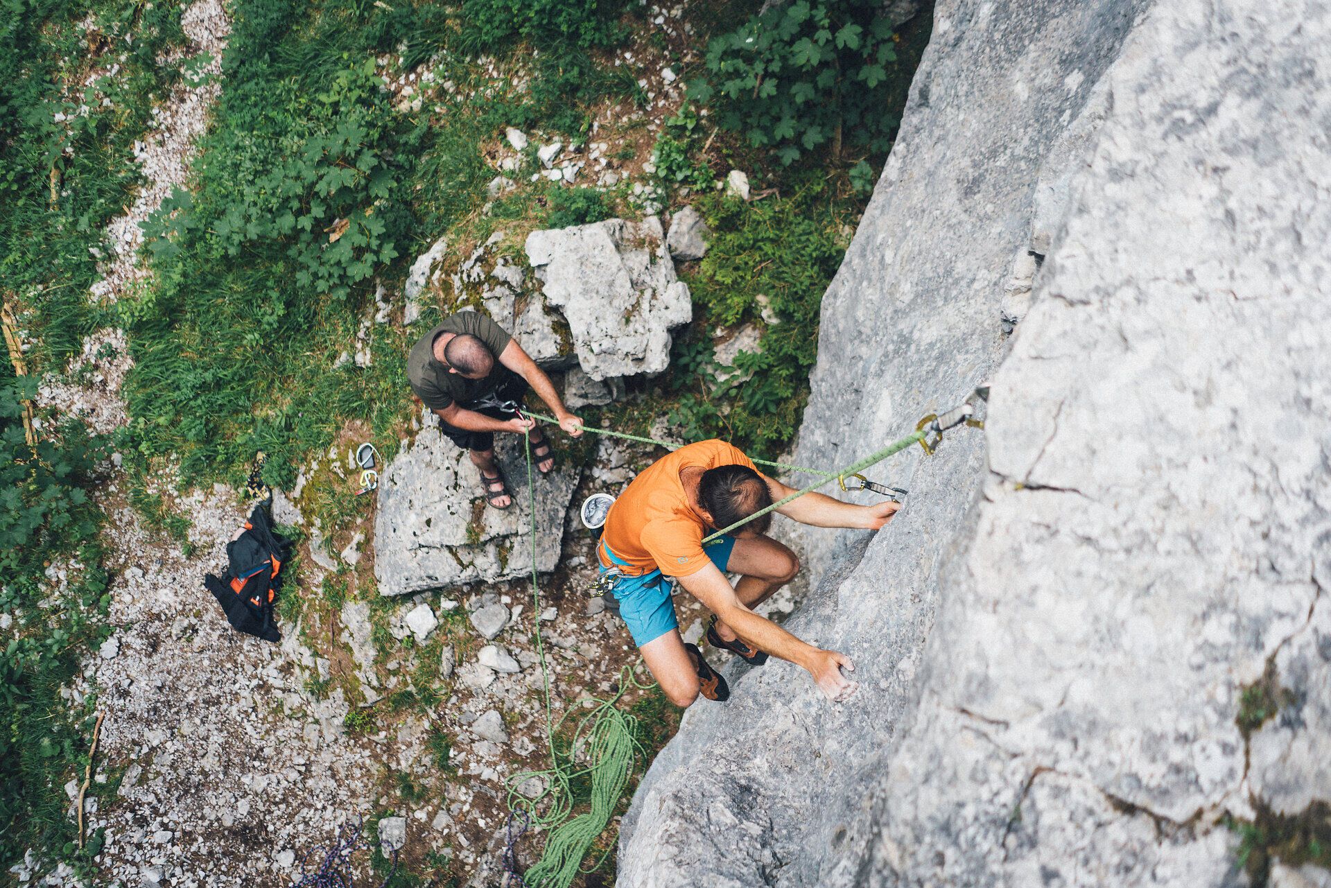 Ein mutiger Bergsteiger erklimmt die steilen Felsen, während sein erfahrener Bergführer ihn sicher mit einem Seil sichert. Umgeben von der üppigen Natur der Wiener Alpen, spürt man die frische Bergluft und die Aufregung des Abenteuers. Diese Szene verkörpert den Geist des Bergsteigens und die Schönheit der alpinen Landschaft.