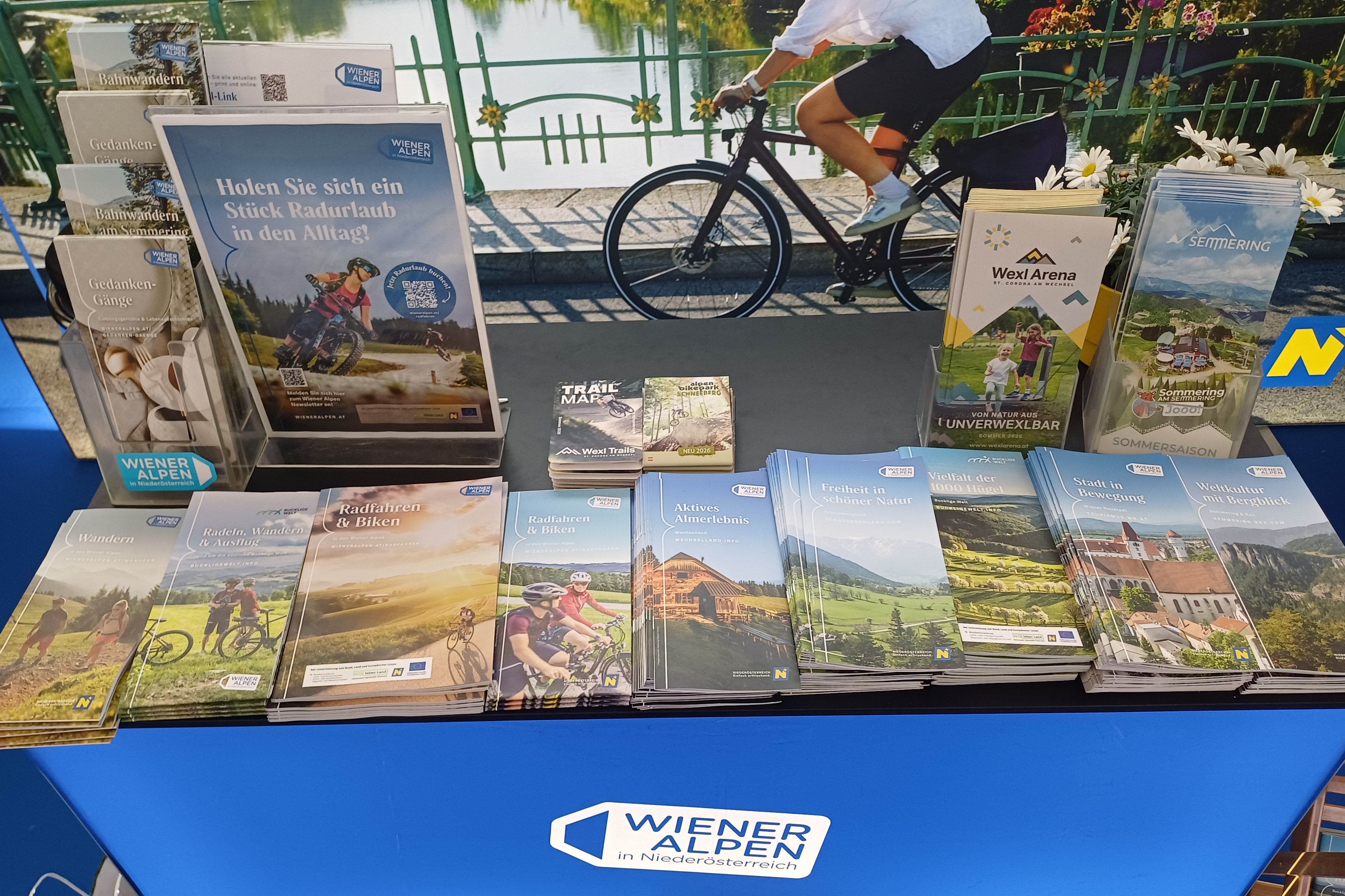 Beim ARGUS Bike Festival liegen geordnet auf einem Pult diverse Wiener Alpen-Prospekte, Rad-Prospekte und Kartenmaterial.