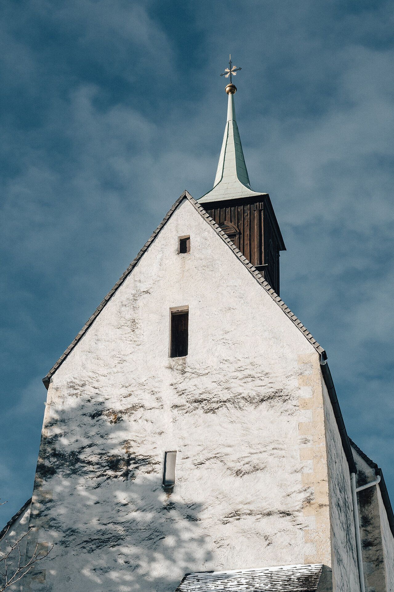 Die schneebedeckte Landschaft strahlt eine friedliche Ruhe aus, während die majestätische Kirche mit ihrem hohen Turm in den klaren Winterhimmel ragt. Hier, in den Wiener Alpen, entfaltet sich die Schönheit des Winters in voller Pracht und lädt zu unvergesslichen Wanderungen ein.