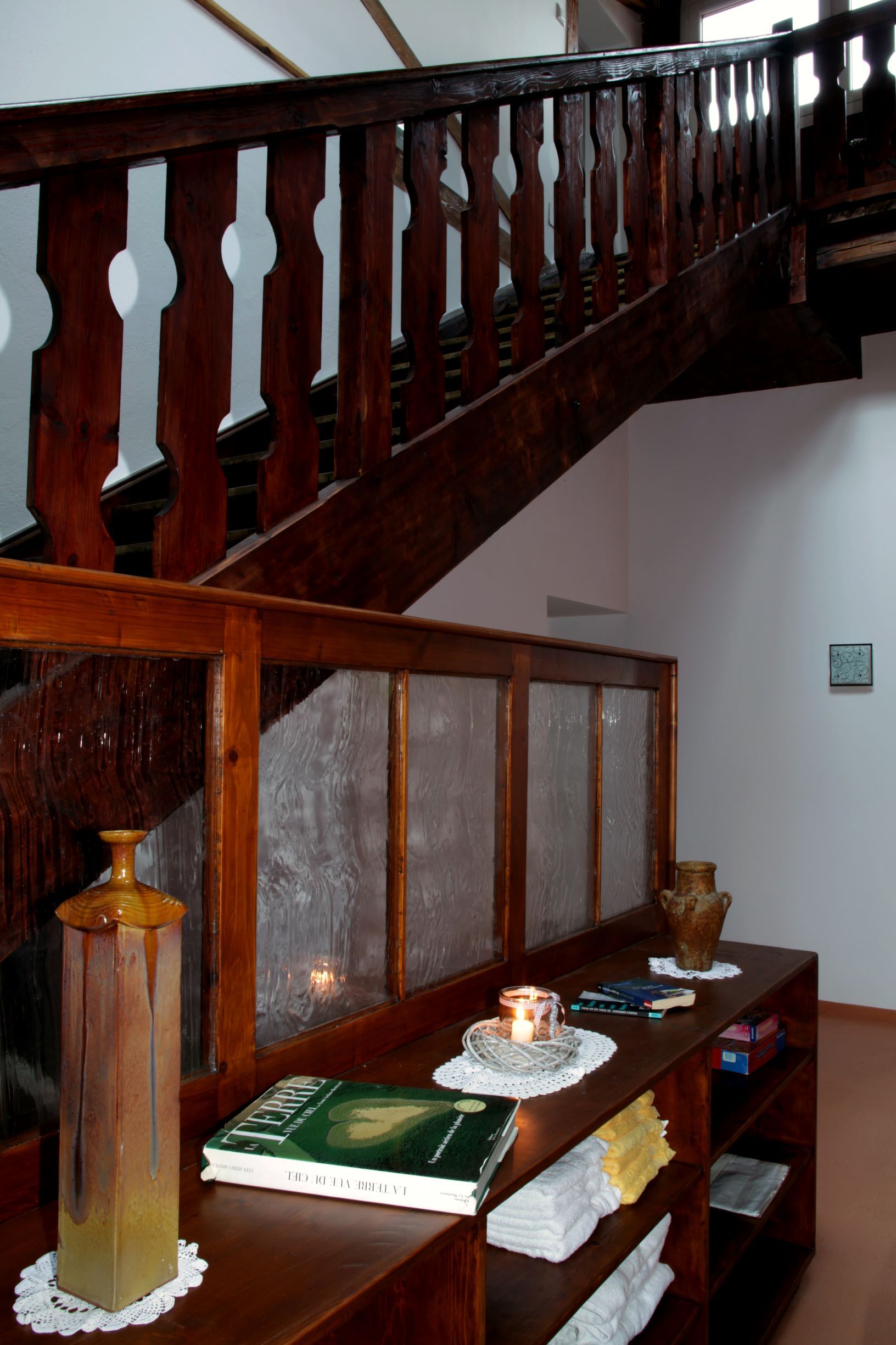 Holztreppe in einem Loft mit dekorativen Elementen und Büchern auf einem Regal.