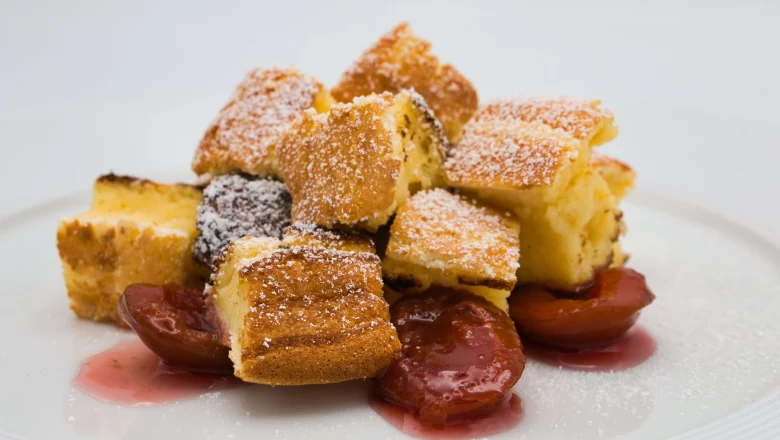 Gestückelter Sauerrahmschmarrn mit Zwetschkenröster auf einem weißen Teller.