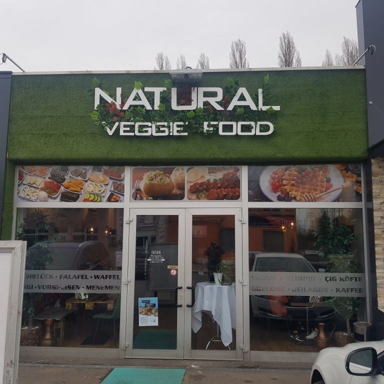 Eingang eines Restaurants mit dem Namen 'Natural Veggie Food'.