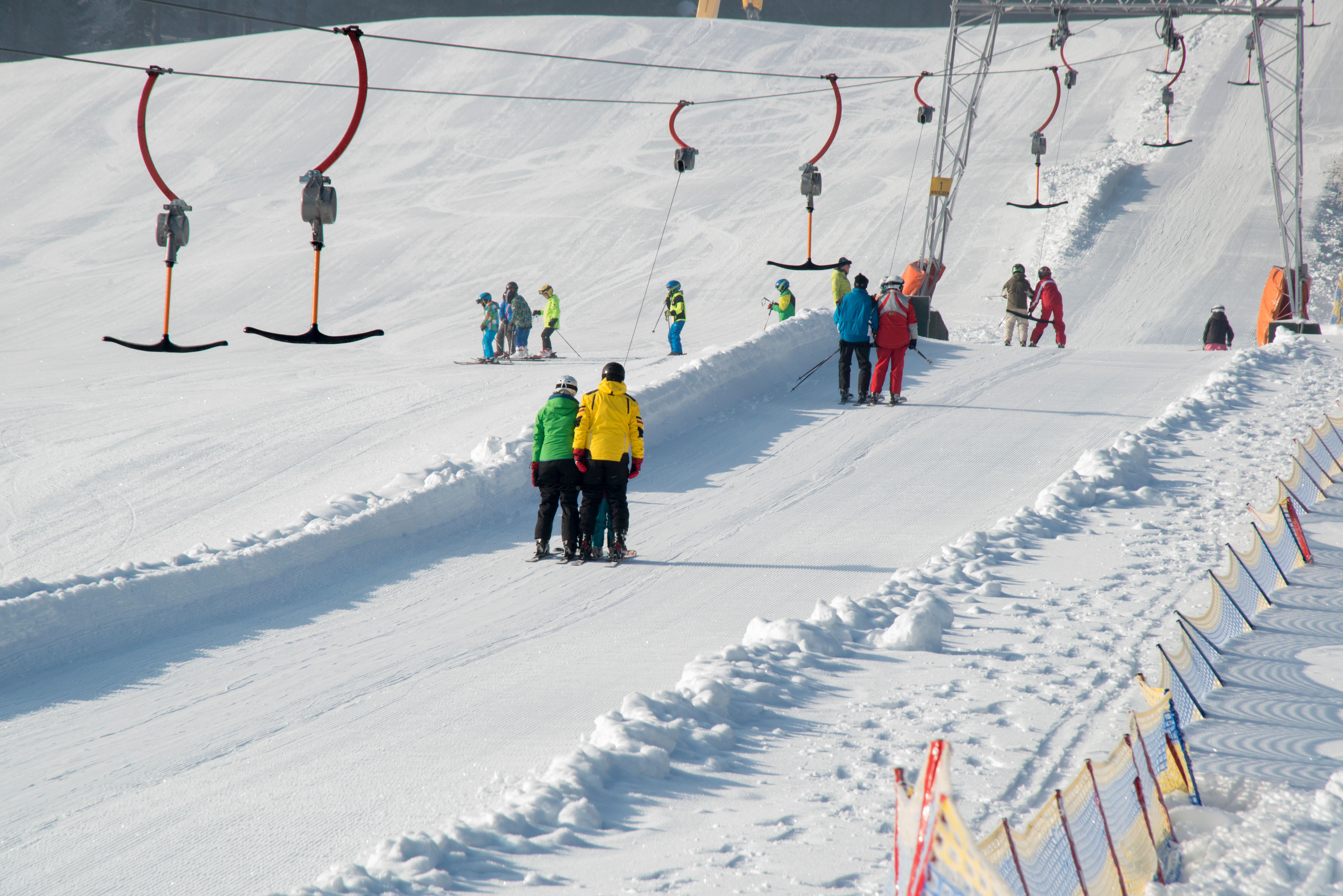 Snowy landscape with skiers and a T-bar lift