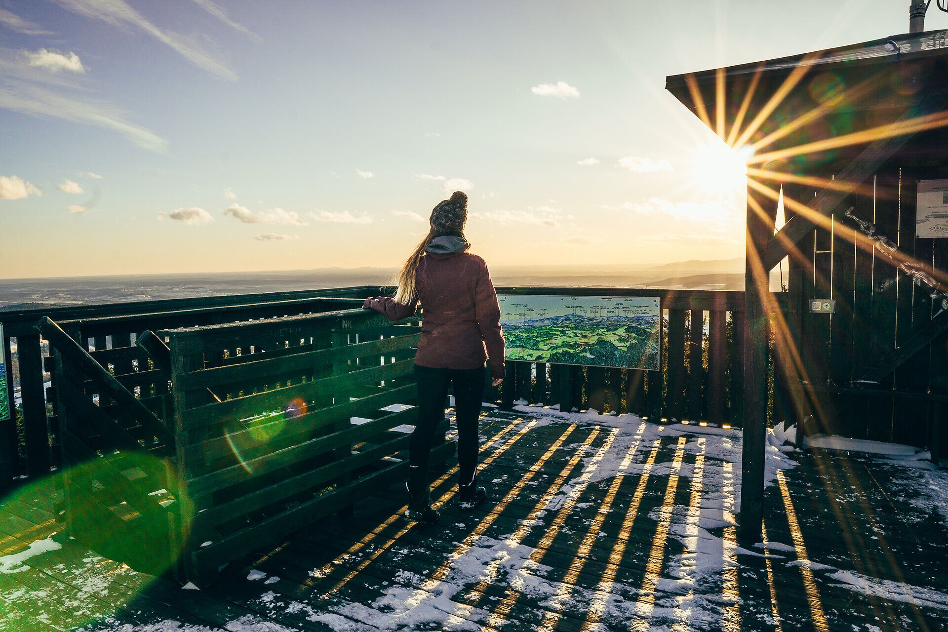Die winterliche Landschaft erstreckt sich majestätisch unter einem strahlend blauen Himmel. Die warmen Sonnenstrahlen brechen durch die kalte Luft und verleihen der schneebedeckten Umgebung einen zauberhaften Glanz. Hier oben, umgeben von der Stille der Natur, wird jeder Moment zu einem unvergesslichen Erlebnis.