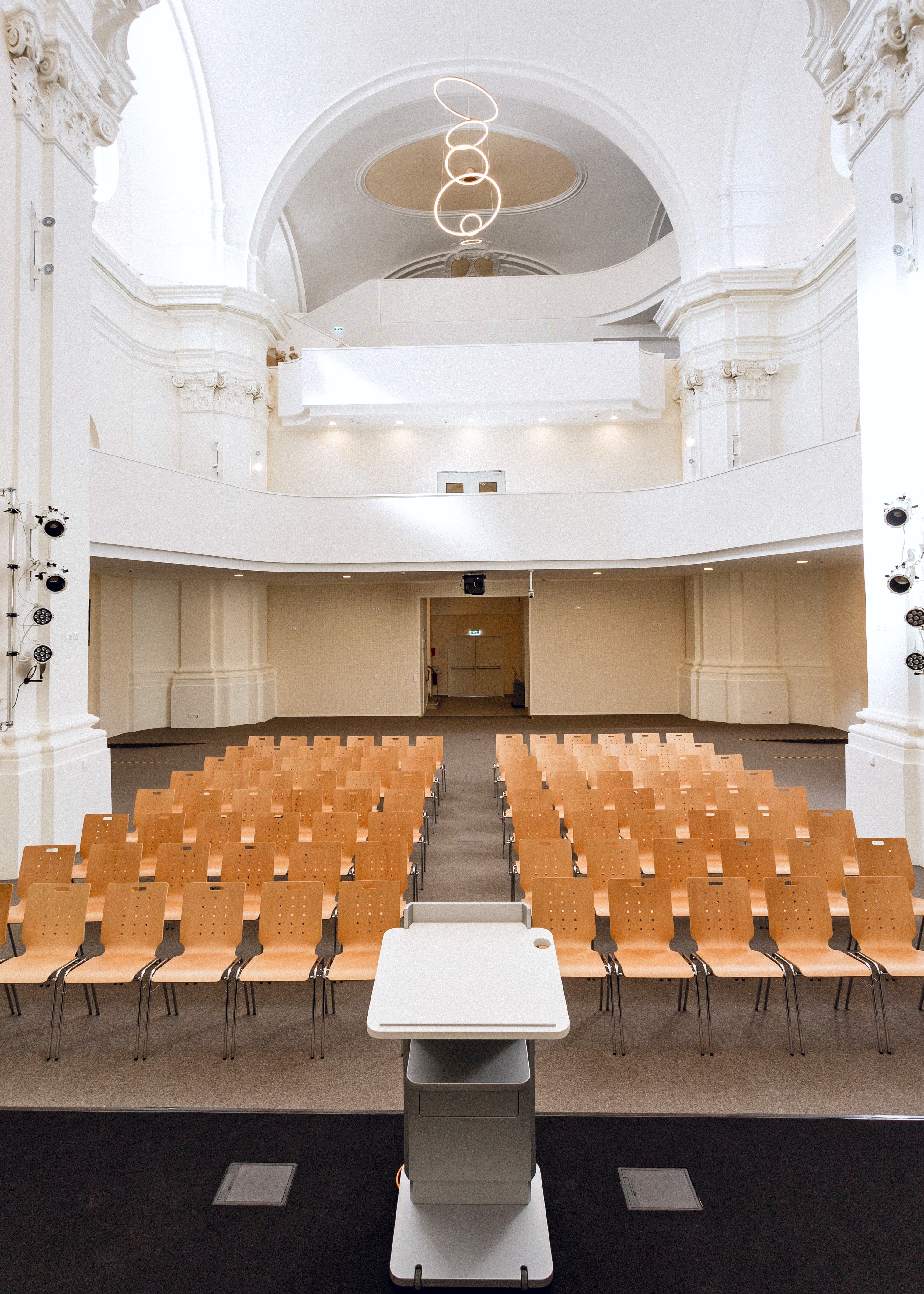 Heller Saal mit Galerie und Stuck.