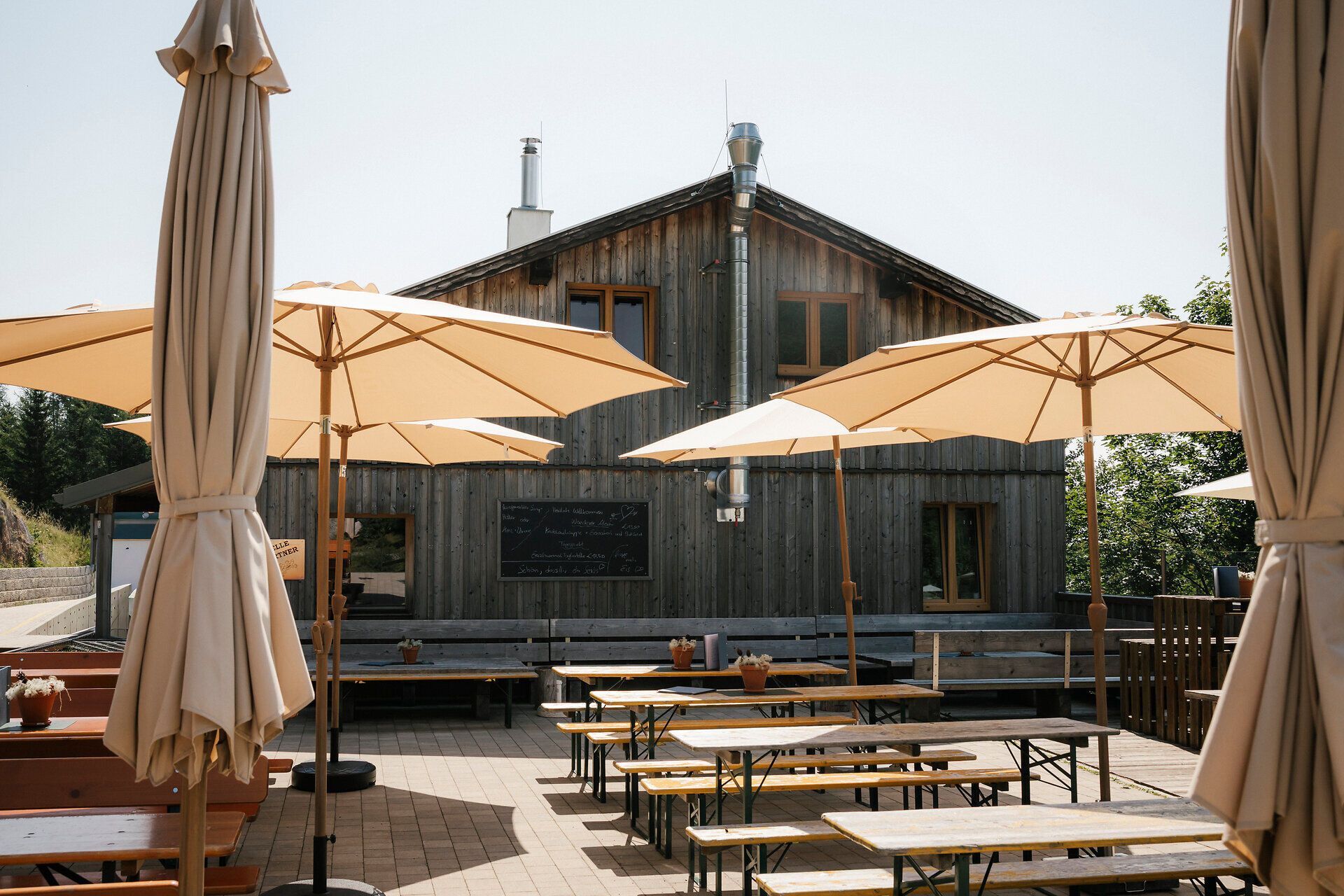 Terrace at the Baumgartner shelter, featuring benches and large umbrellas