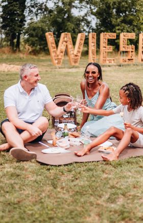 Menschen beim picknicken auf einer Wiese. 