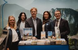 Drei Damen und zwei Herren vor dem Wiener Alpen Stand